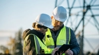 Employés devant un pylone électrique