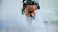 Jeune femme regardant dans un microscope