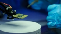 Petite pièce électronique tenue dans un bras robotisé
