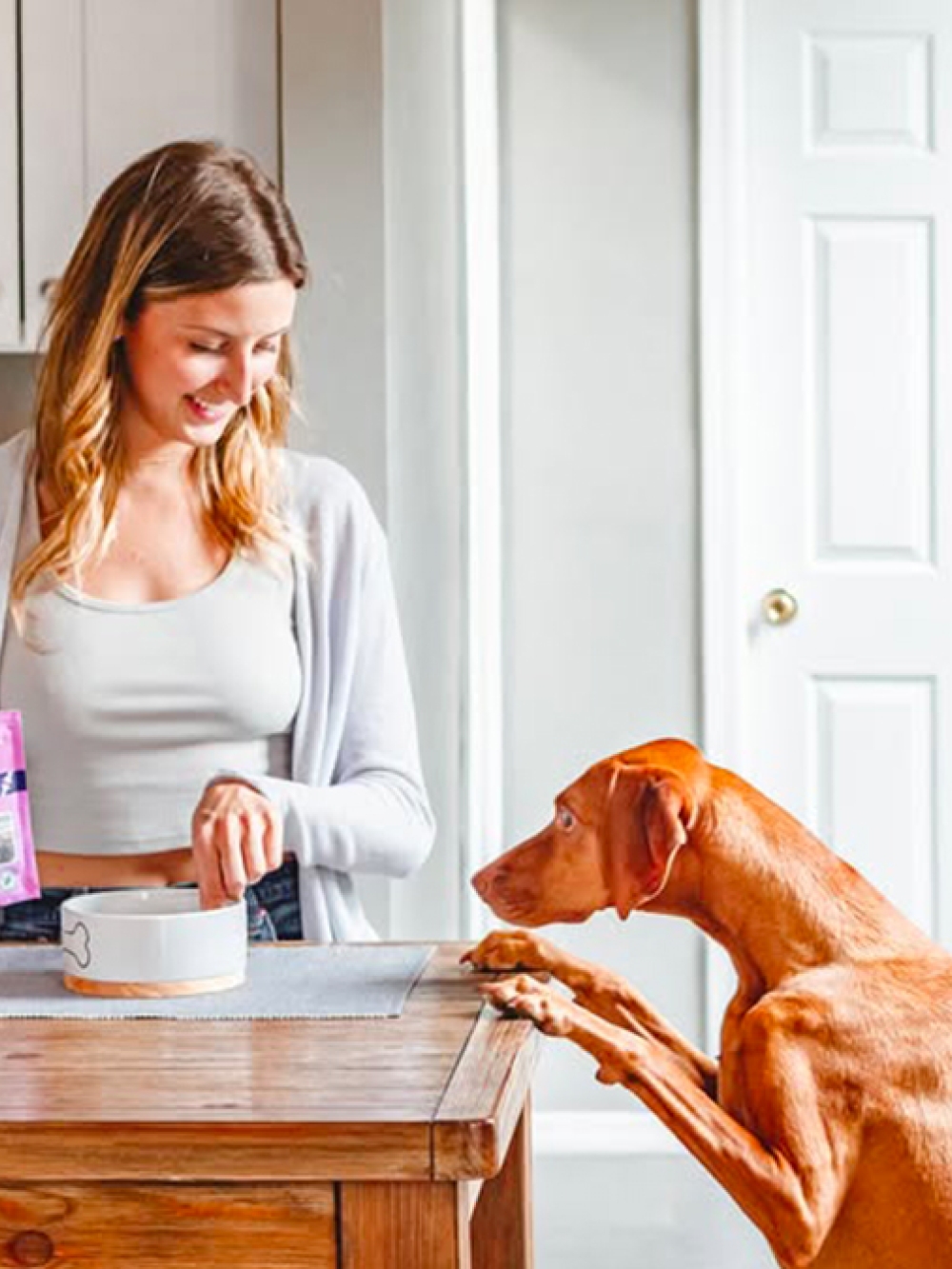 Propriétaire de chien avec des sacs de nourriture pour animaux