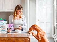 Propriétaire de chien avec des sacs de nourriture pour animaux